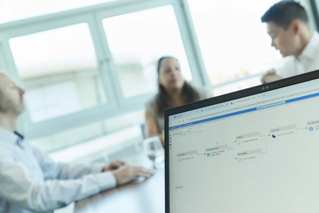 Data pipeline diagram on a laptop screen during a client meeting